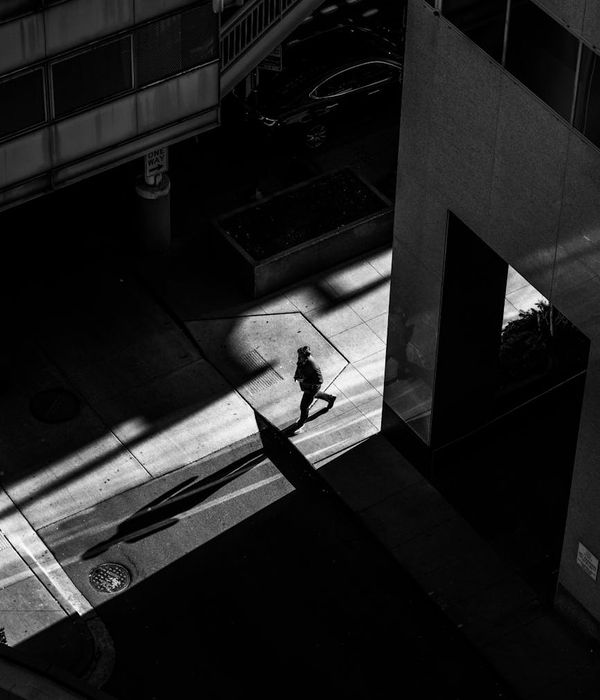 Person feeling serene and balanced, with geometric lemon-colored light patterns and deep shadows.